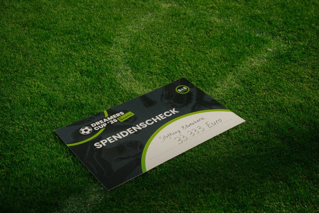Spendenscheck des Dreamers Cup '26 auf dem Rasen der MEWA ARENA Mainz
